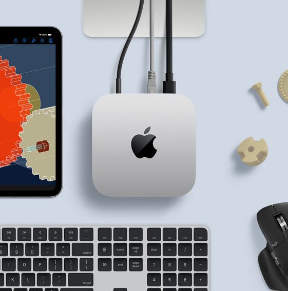 Silver Mac mini M4 on a work surface — with Magic Keyboard, mouse, and an iPad showing a 3D modeling interface, illustrating the macOS development and engineering workloads a cloud server can handle